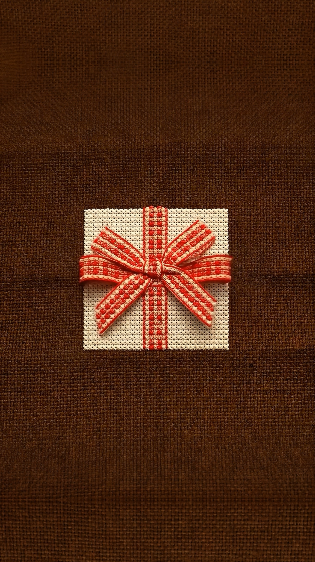 Embroidery of a gift box and ribbon in vintage red, cream, and brown tones to reflect the Givanne Shoppe colors